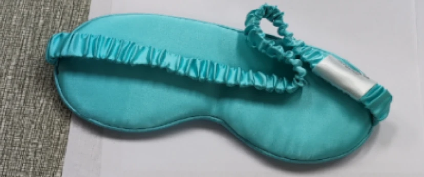 Stapel türkisfarbener Seiden-Augenmasken, bereit zum Verpacken.
