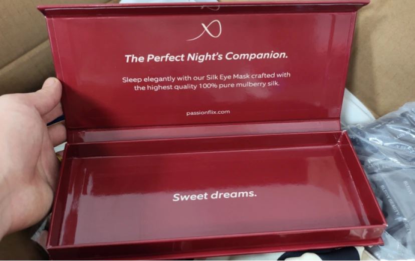 Individuell gestaltete rote Seiden-Augenmasken-Geschenkbox für PASSIONFLIX mit Markenbotschaft im Inneren.
