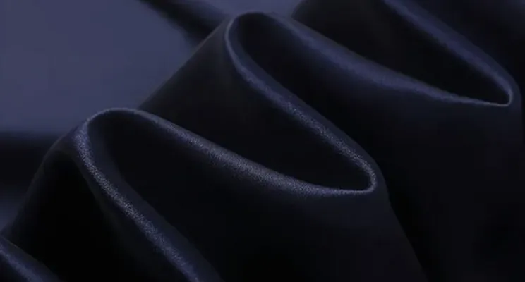 Black stretch silk fabric close-up showing satin sheen with elastic recovery