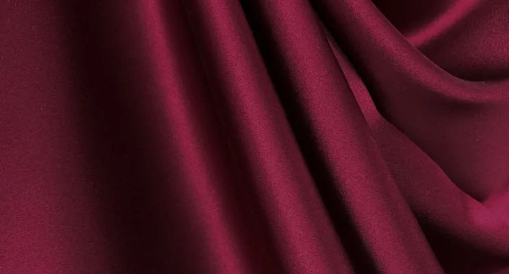 Red silk charmeuse fabric detail showing deep saturated color