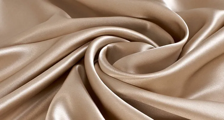 Champagne silk charmeuse fabric swatch in warm neutral tone