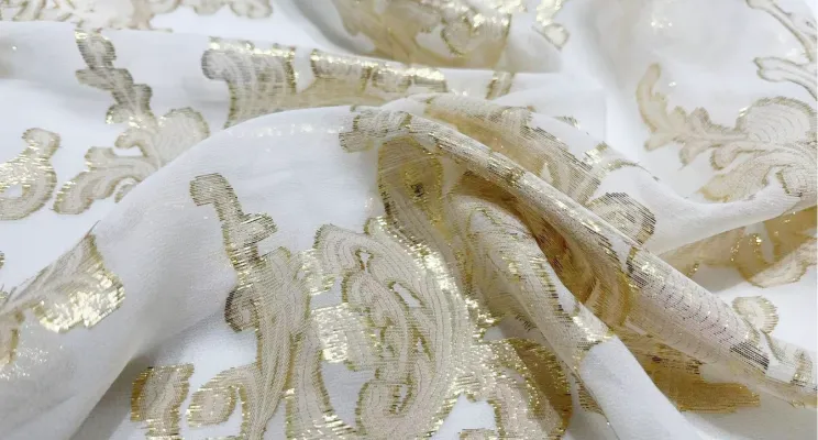 Gold silk jacquard fabric close-up with metallic woven design