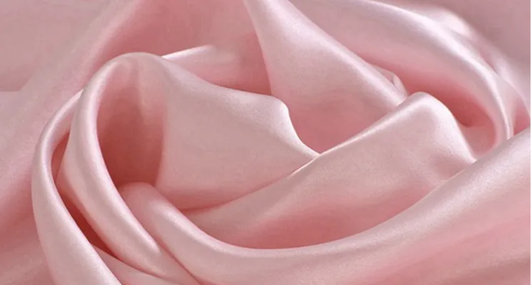 Pink silk charmeuse fabric close-up with soft satin finish