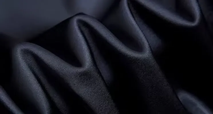 Black silk charmeuse fabric detail with light-reflecting sheen