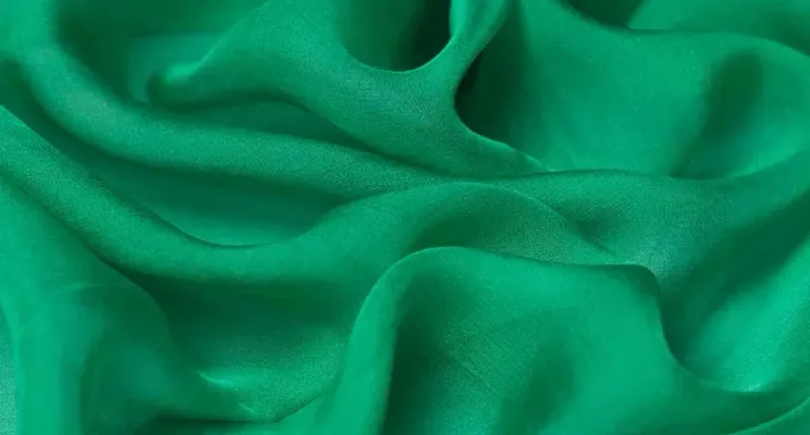 Green silk chiffon fabric swatch with emerald transparency